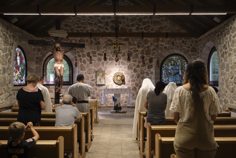 Pilgrims praying in a stone chapel